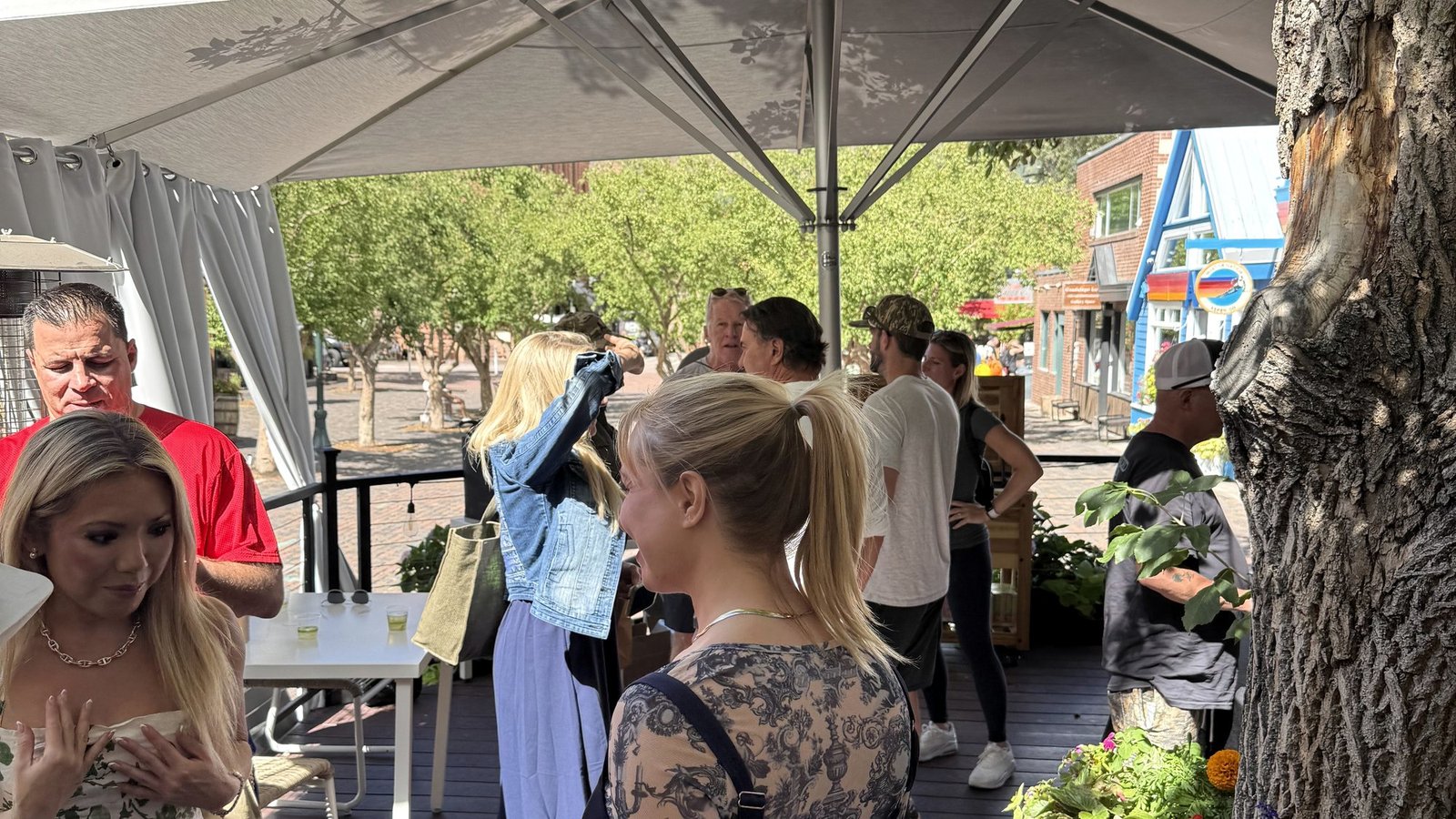 Guests standing under white umbrellas on the Bosq patio in Aspen during the Art of the Cactus afternoon
