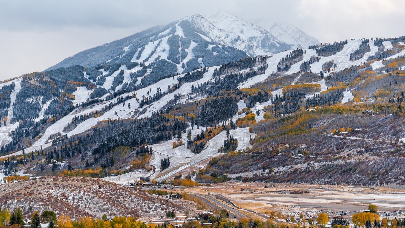 Aspen Mountain above the valley floor, with the airport apron and Highway 82 below