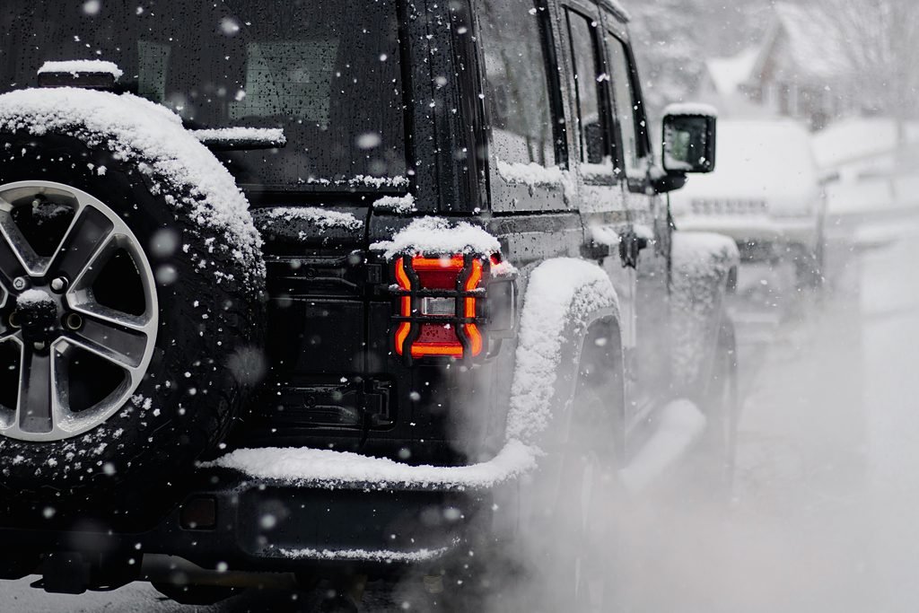 A dark vehicle moving through falling snow in Aspen