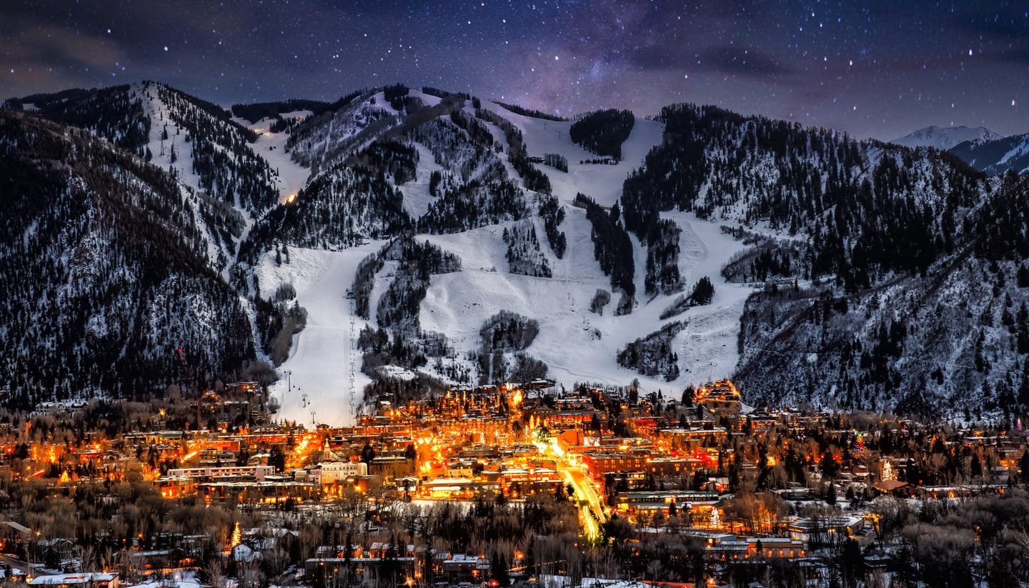 Aspen at night beneath the lit runs of Aspen Mountain