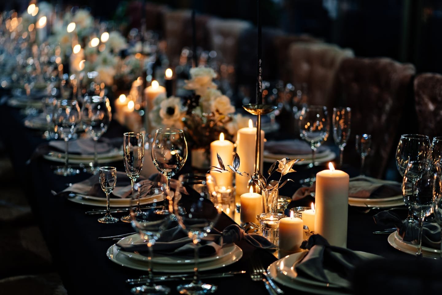 A long candlelit table set for dinner