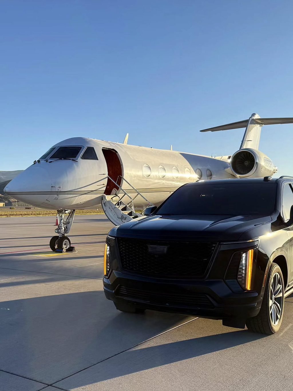 Black SUV waiting beside a private jet on the ramp