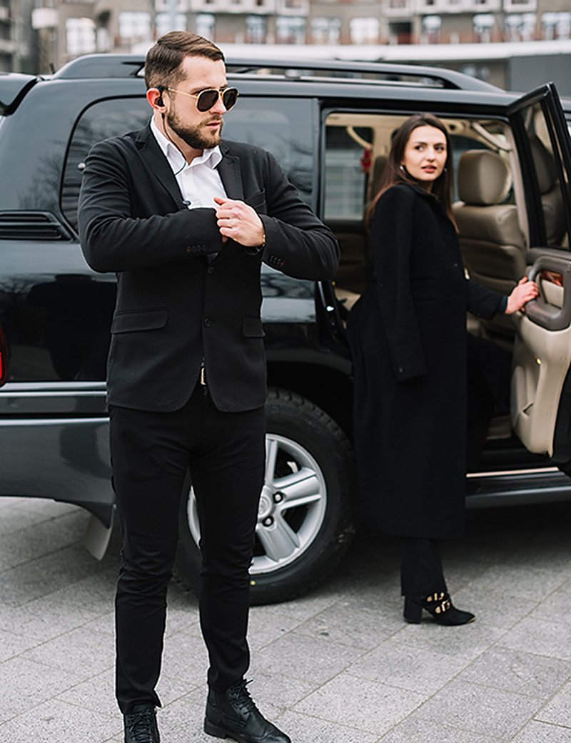 Driver holding a vehicle door beside a black SUV